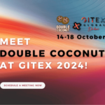 Promotional banner for Double Coconut at GITEX 2024. The banner features a colorful gradient background with shades of orange, red, and blue. It highlights the message 'Meet Double Coconut at GITEX 2024!' along with the event dates, '14-18 October,' and logos for Double Coconut and GITEX Global Dubai. A button at the bottom reads 'Schedule a Meeting Now.